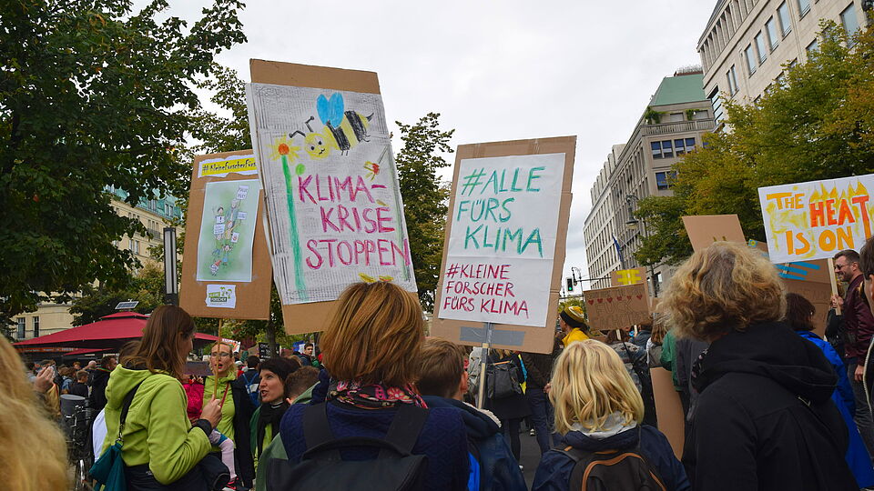 Demonstrierende mit Schildern in Berlin unterwegs