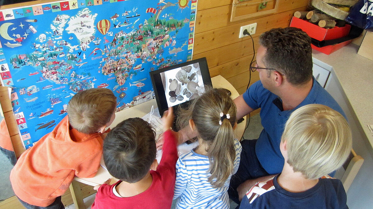Kinder betrachten eine Weltkarte