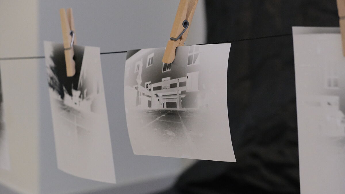Zwei entwickelte Schwarz-weiß-Fotos hängen auf einer Wäscheleine.