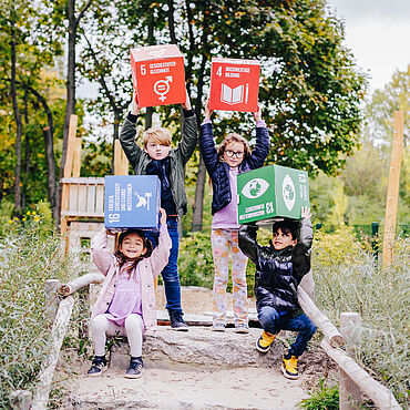 Kinder halten die Nachhaltigkeitsziele (SDG) in die Luft